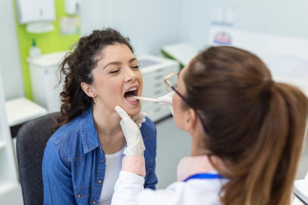 female patient opening her mouth doctor look her throat otolaryngologist examines sore throat patient